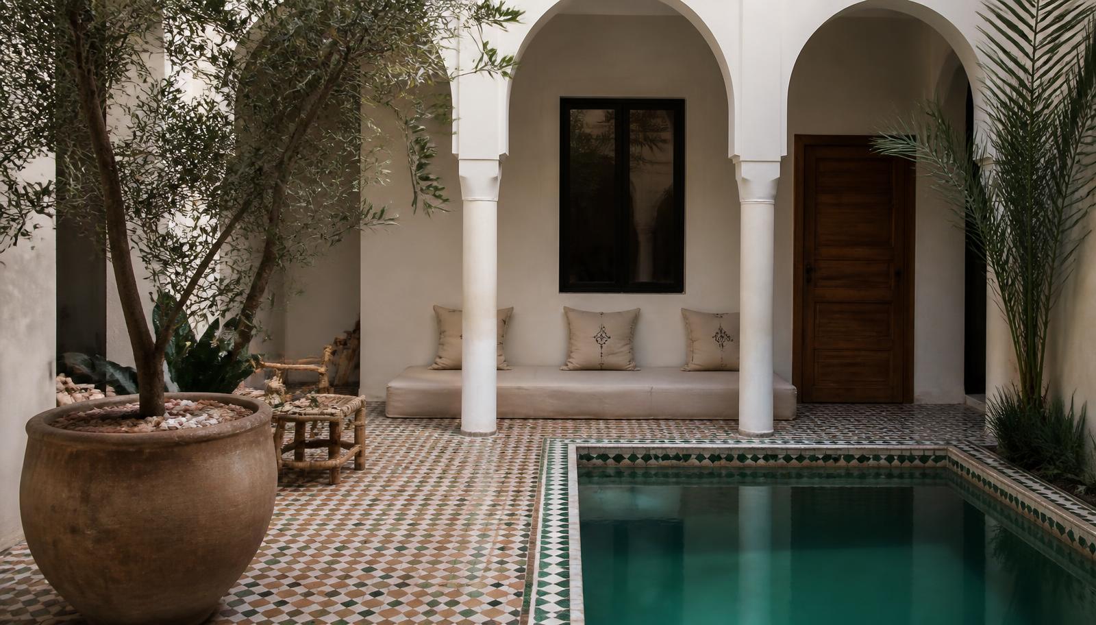 Binnenplaats van een riad met olijfboom, zellige-tegels en een klein zwembad